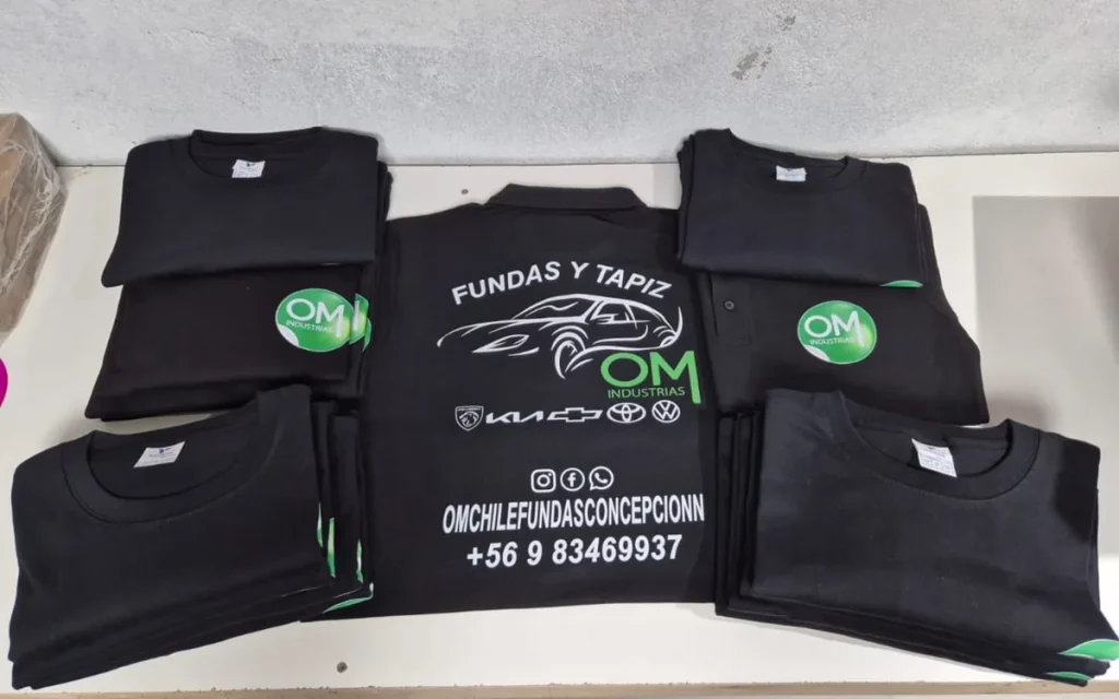 Set de poleras corporativas negras con logo de empresa, dobladas y listas para entregar