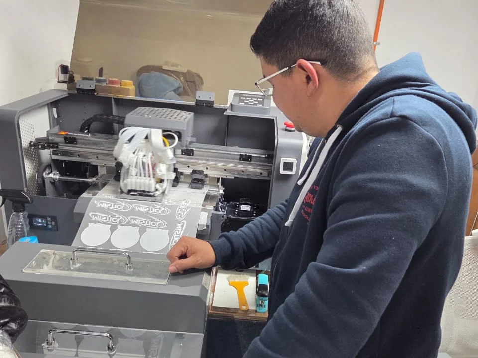 Operario de Fénix Creations trabajando en la impresora DTF del taller en Concepción