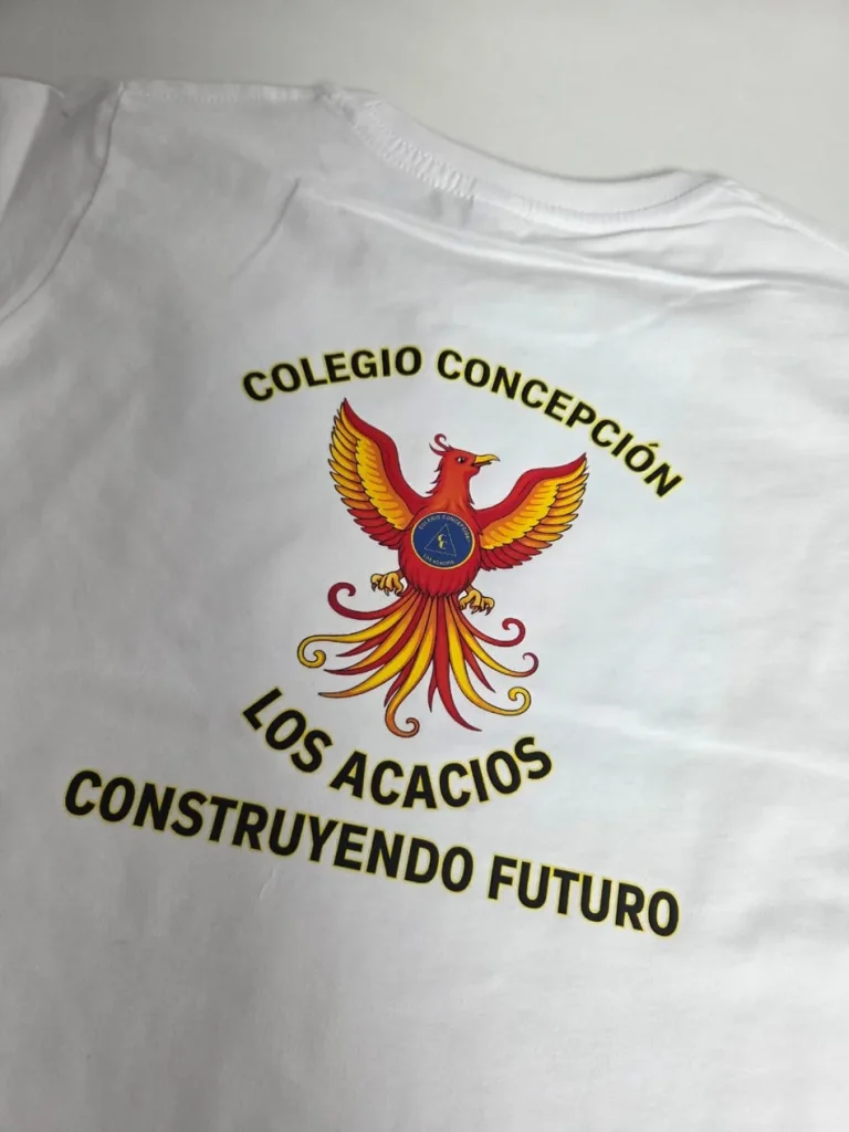 Polera institucional blanca con el escudo del colegio estampado a gran tamaño en el pecho