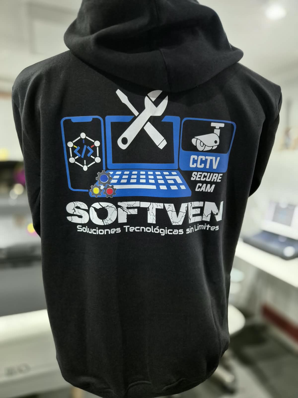 Polerón negro con el logo Softven estampado en la espalda en azul, blanco y gris.